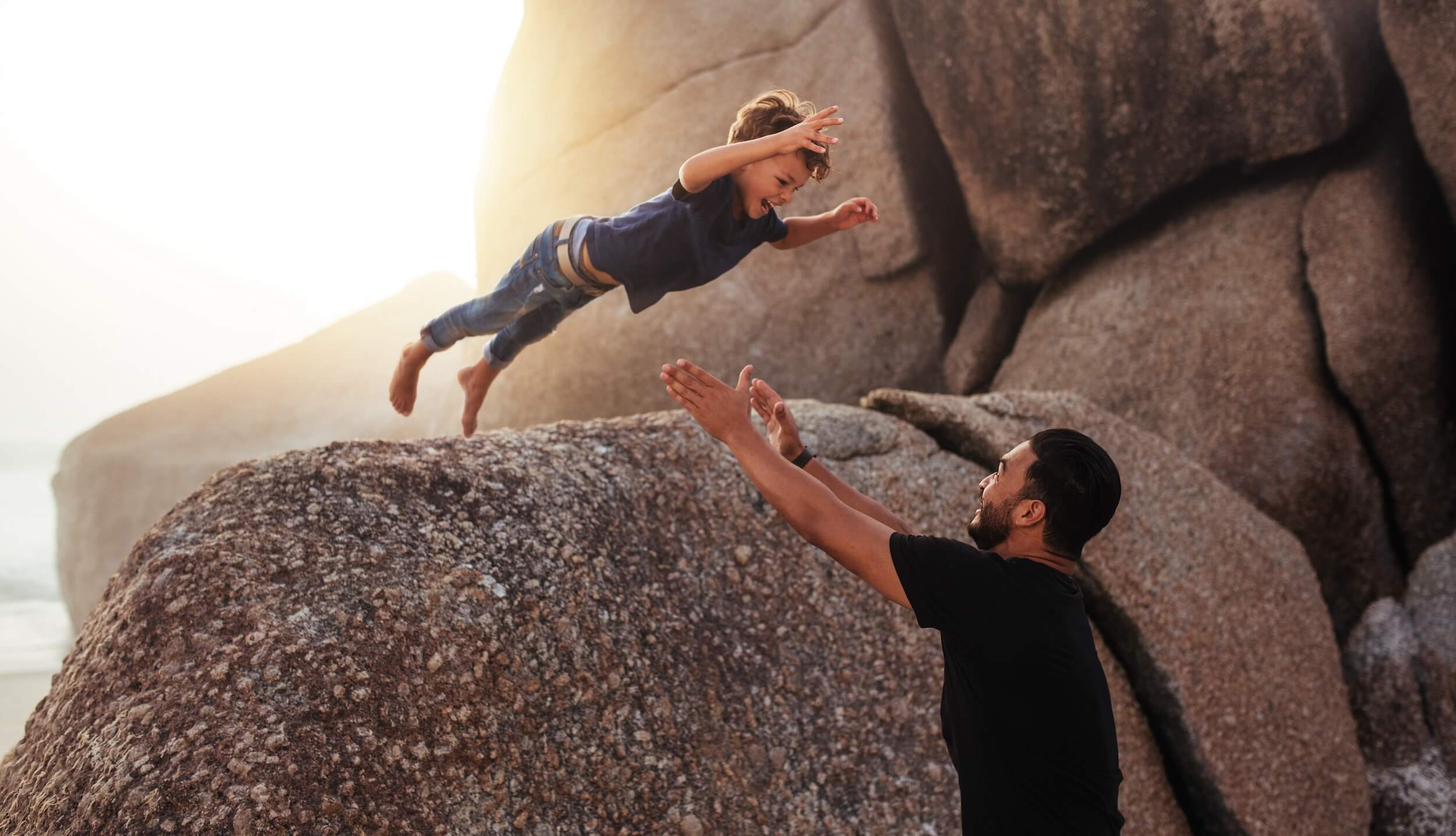 Why trust is imperative when selling creative ideas. Small boy taking a jump off a rock towards parent.